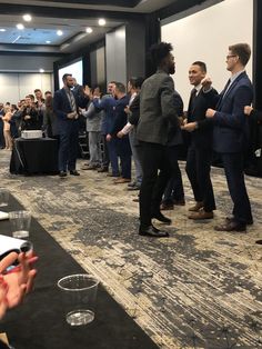 a group of people standing in front of a crowd at a business meeting or conference