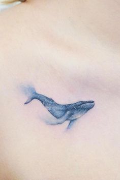 a woman's stomach with a tattoo of a whale on the side of her chest