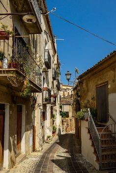 an alleyway in the old town with stairs and balconies on either side