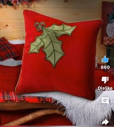 a red pillow sitting on top of a bed next to a wooden sleigh