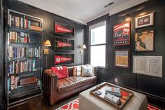 a living room filled with furniture and bookshelves next to a wall covered in pictures