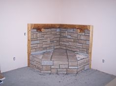 an unfinished room with a brick fireplace in the corner