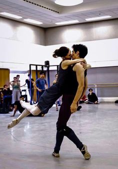 two people are dancing in an indoor dance studio