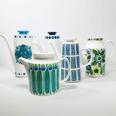 a group of teapots and cups with designs painted on them