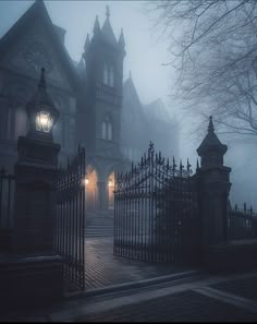 a foggy night in front of a house with an iron gate and street light