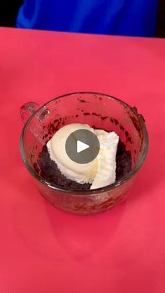 a glass bowl filled with pudding on top of a pink table