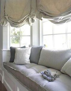 a window seat with several pillows on it