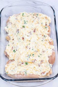 a casserole dish with cheese and meat in it on a marble counter top