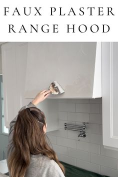 a woman is painting the wall in her kitchen