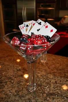 a martini glass filled with dice and playing cards on top of a counter next to a stove