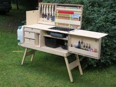 an outdoor work bench with utensils and tools in the drawer on it's side