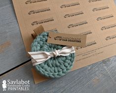 a crochet dishcloth with a tag on it sitting next to a cardboard box