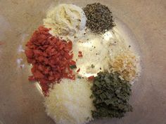 an assortment of spices and seasonings in a glass bowl on top of a table