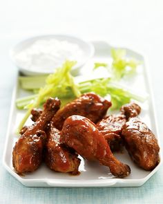 chicken wings and lettuce on a plate with dipping sauces in the background