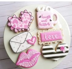 decorated cookies are arranged on a plate with the words love spelled in pink and white