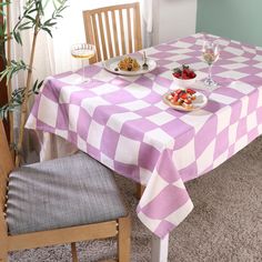 a table with plates of food on it and two glasses of wine in the background