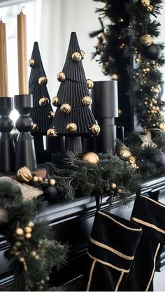 a fireplace mantle decorated for christmas with black and gold decorations