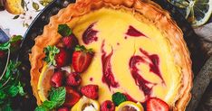 a pie with strawberries and lemons on top