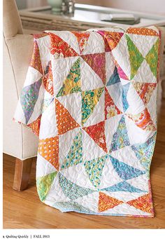 a colorful quilt sitting on top of a chair