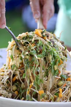 someone is cutting up some food in a bowl