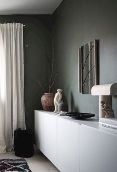 a living room with green walls and white furniture