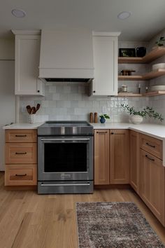 a kitchen with wooden cabinets and stainless steel stove top oven in the middle of it