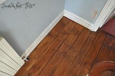 a wooden floor with a radiator next to it and a wall that has writing on it