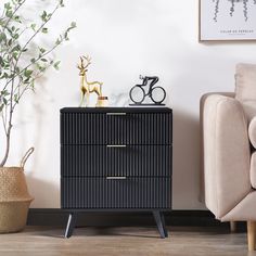 a black cabinet with two drawers and a gold handle on it in a living room