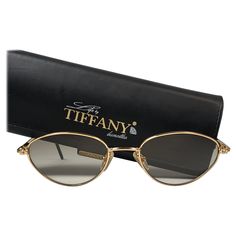 New Tiffany gold plated cat eyes frame. Spotless brown gradient lenses. Made in Italy. Produced and design in 1990's. This item may show minor sign of wear due to storage. 1960s Sunglasses, Tiffany Gold, Tiffany Rose, Black Round Sunglasses, Vintage Tiffany, Sunglasses Logo, Chanel Sunglasses, Cat Eyes, Brown Gradient