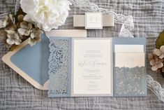 the wedding stationery is laid out on top of the bed with flowers and lace