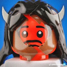 a lego figurine with horns on it's head is shown in front of a blue background