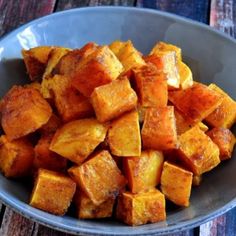 a bowl filled with cubed potatoes on top of a wooden table