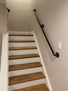 an empty staircase with wooden steps and handrails in a new home's entryway