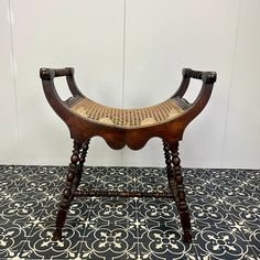 an old wooden chair sitting on top of a tiled floor