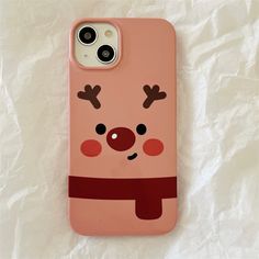 a pink phone case with reindeers on it sitting on top of a white sheet