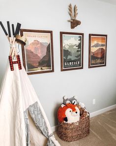 a teepee tent in the corner of a room with pictures on the wall above it