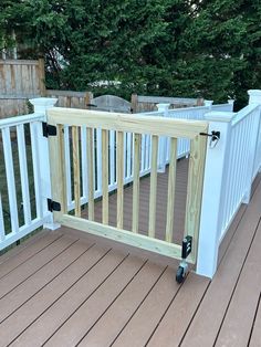 a wooden deck with white railings and wood flooring on the side of it