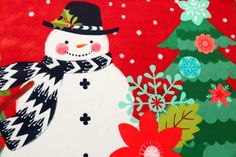 a snowman standing in front of a christmas tree with poinsettias and evergreens