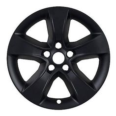 a black wheel cover with holes in the center and four spokes on each side