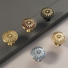 an assortment of knobs and handles on a gray surface, including one with a sunburst design