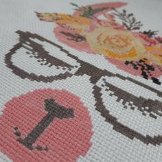 a cross - stitch pattern with flowers and scissors on the bottom half of it,