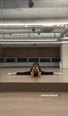 a woman laying on the floor taking a selfie with her cell phone in an empty room