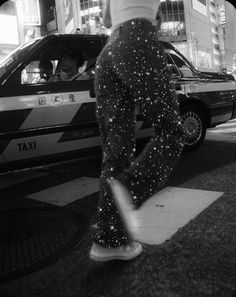 a person standing on the sidewalk in front of a taxi cab with stars all over it