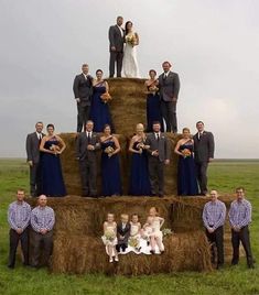 a large group of people standing on top of hay bales