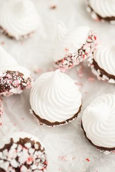 there are many cookies with white frosting and sprinkles on the table