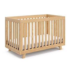 a small wooden crib with white sheets on the bottom and sides, against a white background