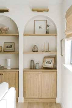 a living room filled with lots of furniture and wooden shelves on top of each other