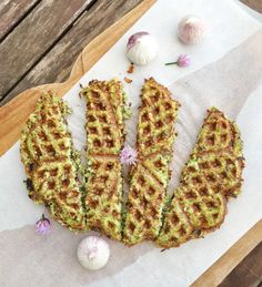 several waffles on a piece of paper next to garlic florets and cloves