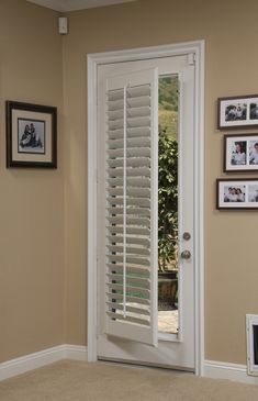 a white door with shutters and pictures on the wall