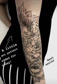 a woman's arm with flowers on it and the words written in black ink